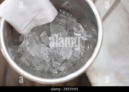 Square pieces of ice in a bucket for cooling alcoholic beverages. Stock Photo