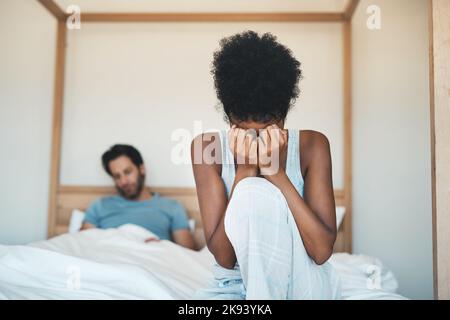 I cant believe he just said that. an unrecognizable young woman crying after an argument with her husband in their bedroom. Stock Photo