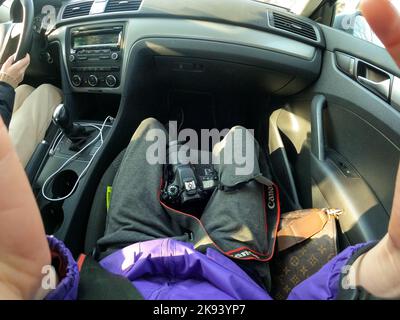 Ukraine Dnepr 10.04.2021 - The Canon 80d camera lies on the legs of the girl in the car, the photo was taken by GoPro Hero9, the photographer in the c Stock Photo