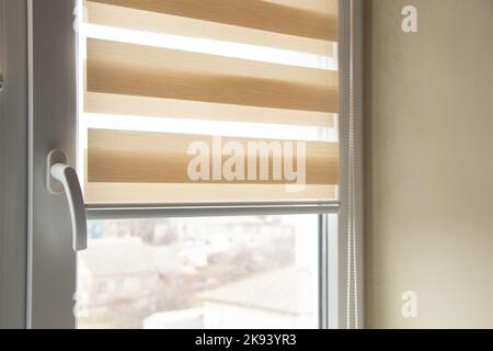 beige blinds day night on the kitchen window close up Stock Photo