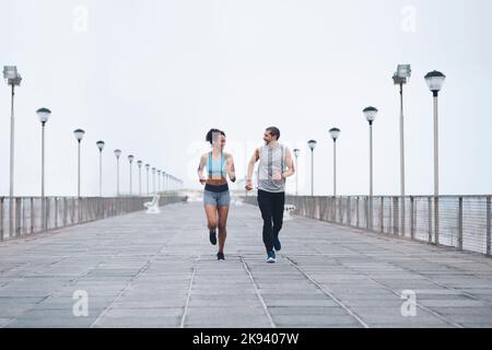 Well make it through to the end. two sporty young people exercising together outdoors. Stock Photo