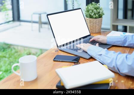 A white screen laptop computer placed on the desk at work. Can put text or media in the area on the white screen Stock Photo