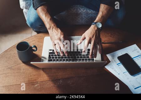 Hes in full work mode. High angle shot of an unrecognizable businessman working on a laptop in his office at home. Stock Photo