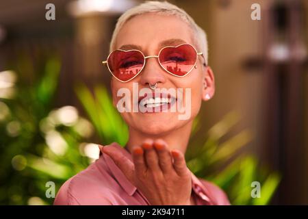 Im all about spreading love and positivity. Portrait of an attractive young woman blowing kisses outdoors. Stock Photo