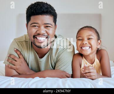 Asian, dad and girl on bed, lying and together with smile, happy and portrait in bedroom in house. Father, child and happiness in room for bonding and Stock Photo