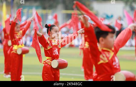 LIUZHOU, CHINA - OCTOBER 26, 2022 - Students perform playing waist drum during the opening ceremony of the track and field meet at Rong 'an County Exp Stock Photo