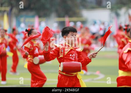 LIUZHOU, CHINA - OCTOBER 26, 2022 - Students perform playing waist drum during the opening ceremony of the track and field meet at Rong 'an County Exp Stock Photo