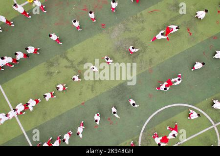 LIUZHOU, CHINA - OCTOBER 26, 2022 - Students perform a folk dance during a track and field meet at Rong 'an County Experimental Primary School in Liuz Stock Photo