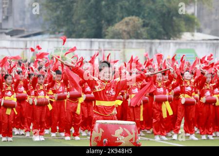 LIUZHOU, CHINA - OCTOBER 26, 2022 - Students perform playing waist drum during the opening ceremony of the track and field meet at Rong 'an County Exp Stock Photo