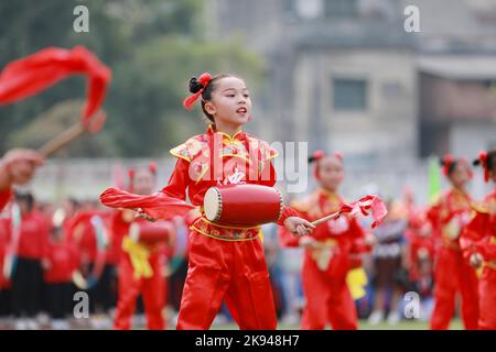 LIUZHOU, CHINA - OCTOBER 26, 2022 - Students perform playing waist drum during the opening ceremony of the track and field meet at Rong 'an County Exp Stock Photo