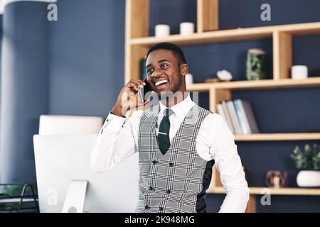 Best news Ive heard all day. a young businessman using a smartphone in a modern office. Stock Photo