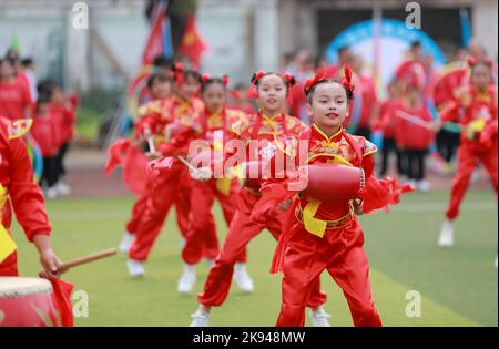 LIUZHOU, CHINA - OCTOBER 26, 2022 - Students perform playing waist drum during the opening ceremony of the track and field meet at Rong 'an County Exp Stock Photo