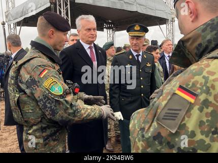 26 October 2022, Lithuania, Pabrade: Lieutenant Colonel Marco Maulbecker (l-r), commander of the NATO Battlegroup in Lithuania led by the German Armed Forces, Gitanas Nauseda, President of Lithuania and King Philippe of Belgium talking to German soldiers. Belgium's King Philippe visited the 'Iron Wolf II' military exercise at the Pabrade military training area on Wednesday. Wearing the uniform of a four-star general, the monarch, together with Lithuanian President Gitanas Nauseda, took a look at the maneuver, which involves some 3,500 soldiers from ten NATO countries and 700 military vehicles Stock Photo