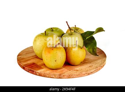 Yellow apples on a wooden cutting board. Bunch of Yellow golden apples on a white background with green leaf, small to big isolated Stock Photo