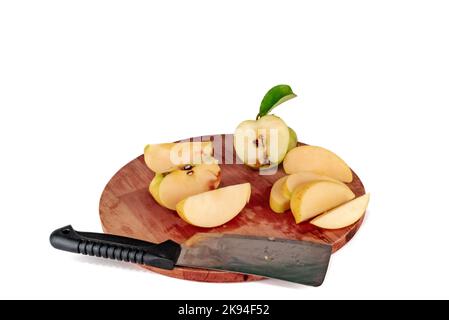 Yellow apple slices cut on a wooden cutting board. Apples cutted with cleaver or chopping knife half golden delicious sliced, green leaf. Stock Photo