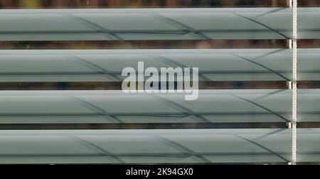 dusty window with horizontal lines of Venetian blinds Stock Photo