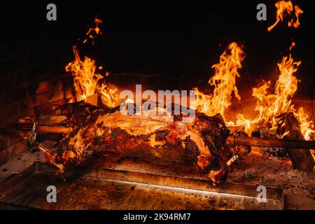 The lamb is cooked entirely on a spit on the fire. Cooking Stock Photo