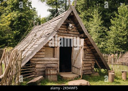 Triangular log houses with wooden roofs behind a fence. Montenegro, north Stock Photo