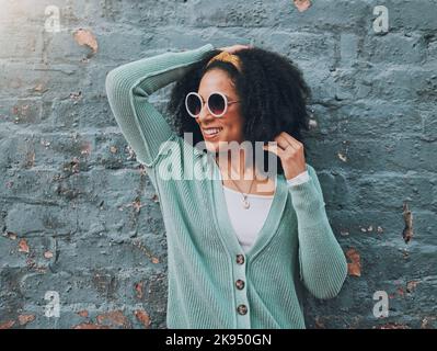 Brazilian woman, fashion and sunglasses by city building wall for fun summer holiday, weekend break or urban vacation. Smile, happy student or afro Stock Photo