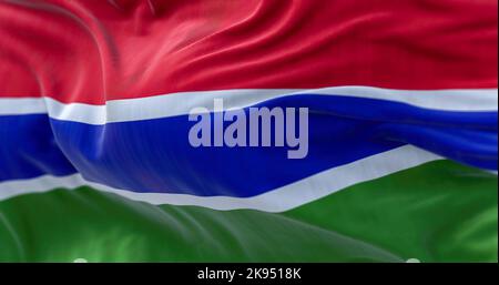 Close-up view of the Gambia national flag waving in the wind. The Republic of the Gambia is a West African state. Fabric textured background. Selectiv Stock Photo