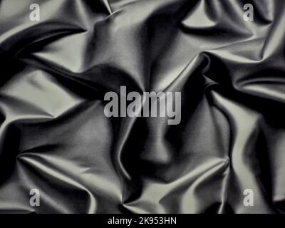 A closeup of a black crumpled silk texture. Stock Photo