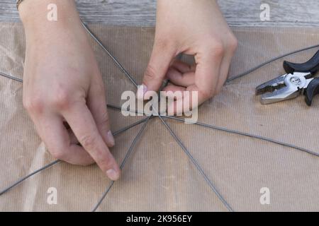 making a dispenser for nesting material for birds or squirrels, step 2: star ist built with wires, series picture 2/5 Stock Photo