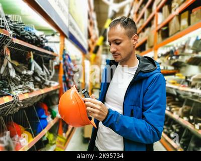 a man measures a helmet in a store Stock Photo