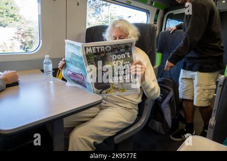 UK, England. A woman on a train reading a London newspaper about the funeral of Queen Elizabeth the 2nd. 17th September 2022. Stock Photo