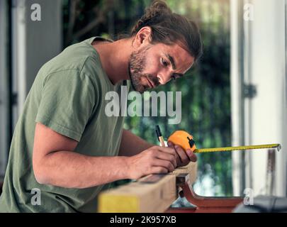 Carpenter, builder and diy for home improvement, development and repair with concentration in house. Man, wood and measure in home with pencil Stock Photo