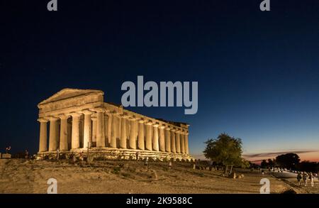 Italy, Sicily, Agrigento. Valle dei Templi. Greek Temple of Concordia 440 bc. Floodlit at night as the sun sets behind. Stock Photo