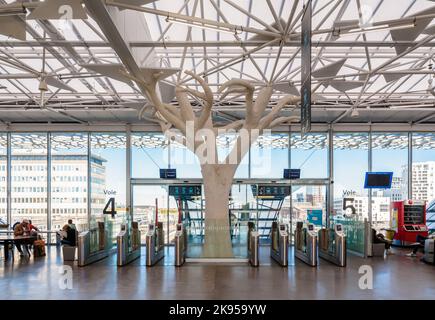Ticket gates and a tree-shape pillar in the mezzanine concourse of the SNCF train station in Nantes, France, designed by architect Rudy Ricciotti. Stock Photo