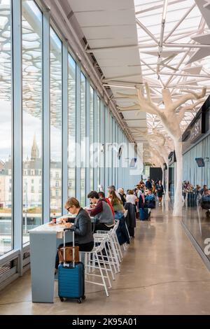 Travelers having a break in the mezzanine concourse of the SNCF train station in Nantes, France, designed by architect Rudy Ricciotti. Stock Photo