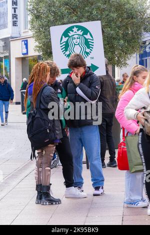 Ireland Eire Dublin Grafton Street street scene teenagers Goth girl torn tights boots dreadlocks Starbucks sign placard chatting leisure friends Stock Photo