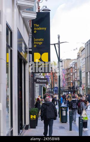 Ireland Eire Dublin Grafton Street pedestrian street scene signs The Academy@ Lunatic Fringe@ Robert Chambers Hairdressing shoppers tourists crowds Stock Photo