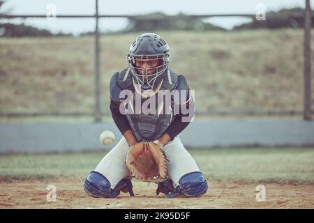 Baseball, sports and catch a ball with a man athlete or catcher on a field during a game or match. Fitness, exercise and training with a male baseball Stock Photo