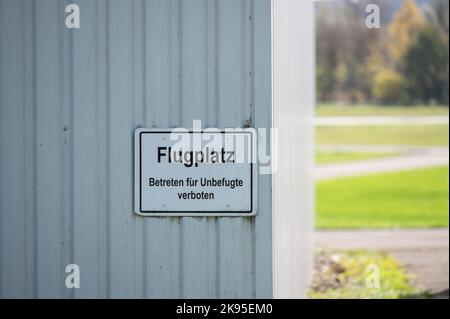 Villingen Schwenningen, Germany. 26th Oct, 2022. A sign reading 'Flugplatz Betreten für Unbefugte verboten' (No Trespassing by Unauthorized Persons) hangs from a hangar at the airfield. A 15-year-old girl had a fatal accident last Saturday while landing with her parachute. Credit: Silas Stein/dpa/Alamy Live News Stock Photo