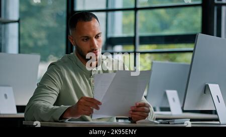 Pensive leader company CEO thinking African businessman boss auditor checking corporate documents financial audit male worker busy with paperwork Stock Photo