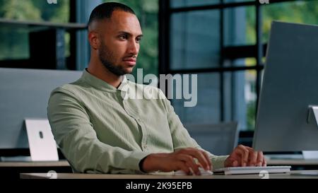 African American serious business man employer entrepreneur manager CEO typing keyboard computer in office work with net online project writing Stock Photo