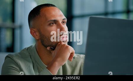Closeup pensive thoughtful African Latina man manager writer journalist specialist entrepreneur holding pencil thinking pondering idea think planning Stock Photo