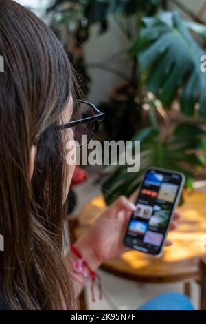 A vertical shot of a young Hispanic woman checking her smartphone Stock Photo