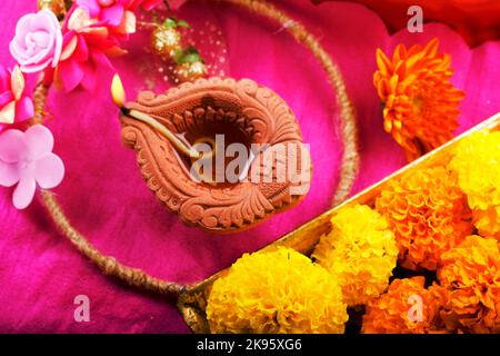 Happy Diwali, Clay Diya lamps lit during Diwali, Hindu festival of lights. Colorful traditional oil lamp diya, flower decoration. Stock Photo