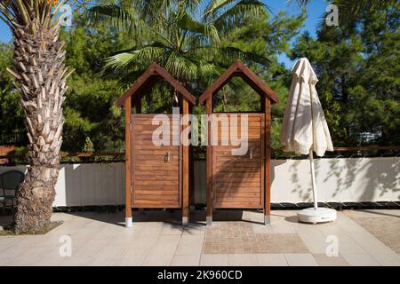 Two wooden changing booths near the pool hotel Stock Photo