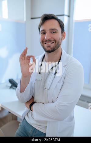 Cheerful doctor posing for the camera in his office Stock Photo