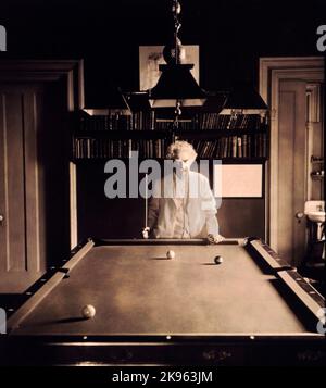 Mark Twain (Samuel L. Clemens) half-length portrait, standing at end of pool table Stock Photo