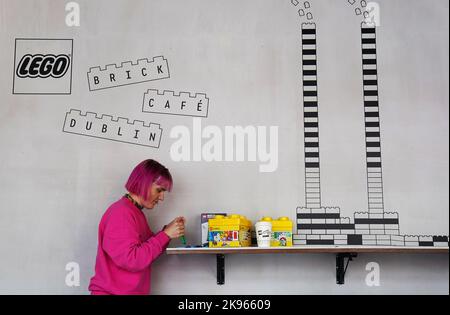 Gemma Sherlock plays with LEGO as she stops for a coffee at the opening of the world’s first experimental LEGO® Brick Cafe in Dublin city centre, an inspiration space giving adults the opportunity to experience and play with LEGO bricks. Picture date: Wednesday October 26, 2022. Stock Photo