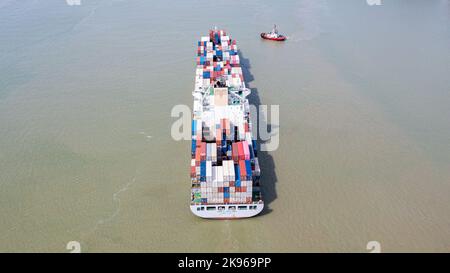 Klang, Malaysia - October 02, 2022: Container ship fully loaded with different container in multiple colors. Aerial view from directly above. Aerial t Stock Photo