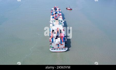 Klang, Malaysia - October 02, 2022: Container ship fully loaded with different container in multiple colors. Aerial view from directly above. Aerial t Stock Photo