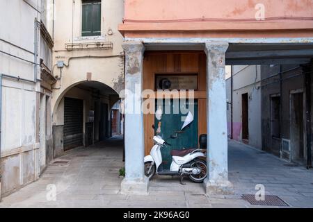 Chioggia, Italy. 20th Aug, 2022. A typical Italian scooter is parked in an alley in Chioggia. Chioggia, a city in the Venetian lagoon that hosts many tourists visiting Venice, has not been included in the Venetian municipal perimeter. Tourists who stay there will have to pay the tax every time they visit Venice from January 16, 2023. (Photo by Laurent Coust/SOPA Images/Sipa USA) Credit: Sipa USA/Alamy Live News Stock Photo