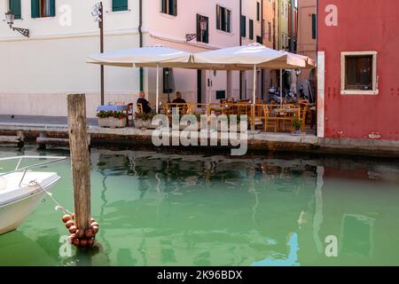 Chioggia, Italy. 20th Aug, 2022. Some tourists enjoying sitting at a terrace along the main canal in Chioggia. Chioggia, a city in the Venetian lagoon that hosts many tourists visiting Venice, has not been included in the Venetian municipal perimeter. Tourists who stay there will have to pay the tax every time they visit Venice from January 16, 2023. (Photo by Laurent Coust/SOPA Images/Sipa USA) Credit: Sipa USA/Alamy Live News Stock Photo