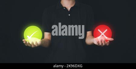 Check green mark and red wrong icon in circle on hand of businesman. Cancel or approved vote. Answer concept. Correct and cross. Stock Photo